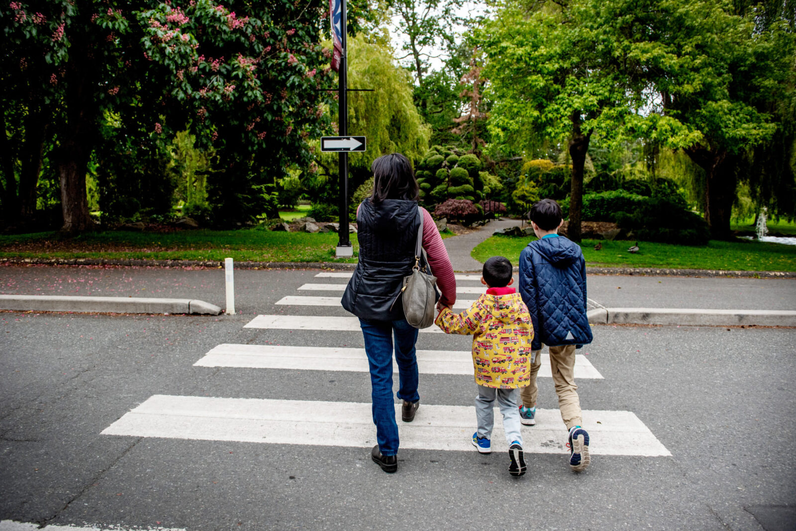 Beacon Hill Park pathways in Victoria BC with a family walking near the duck ponds.