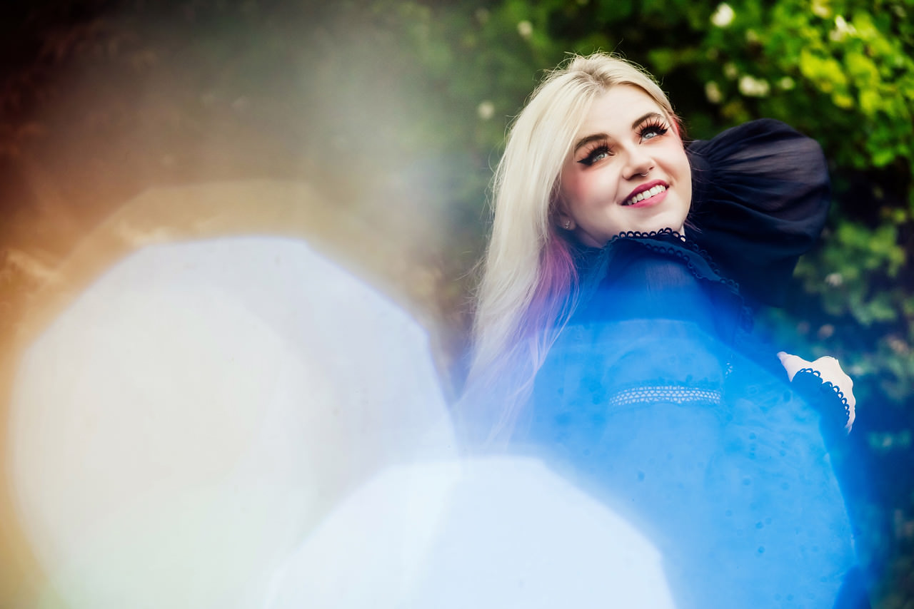 A funky and creative fashion portrait of a fine art grad in Victoria BC. She has blonde hair and fun false eyelashes plus pink undertones.