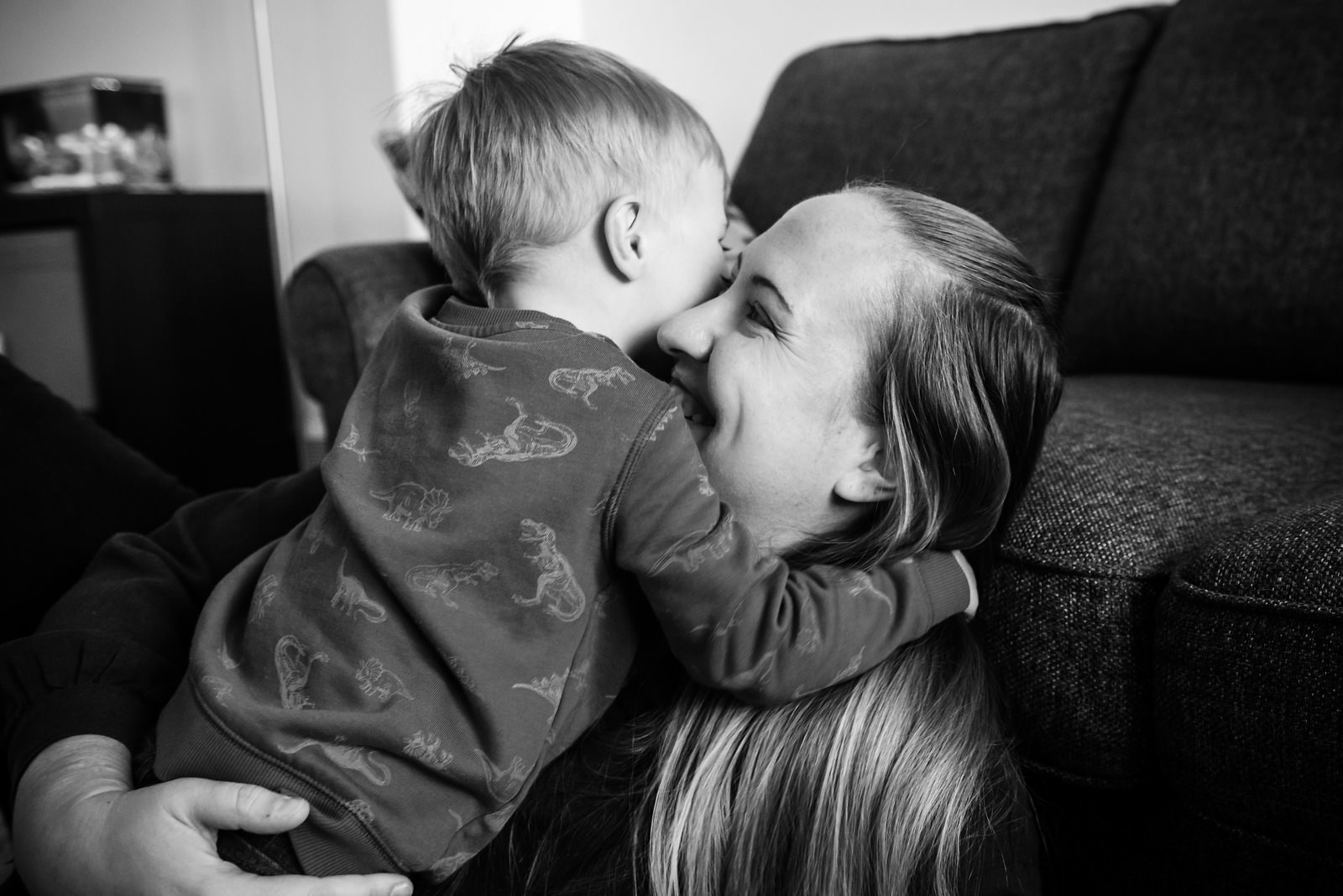 A little boy hugs his mother in the living room at their home in Victoria BC