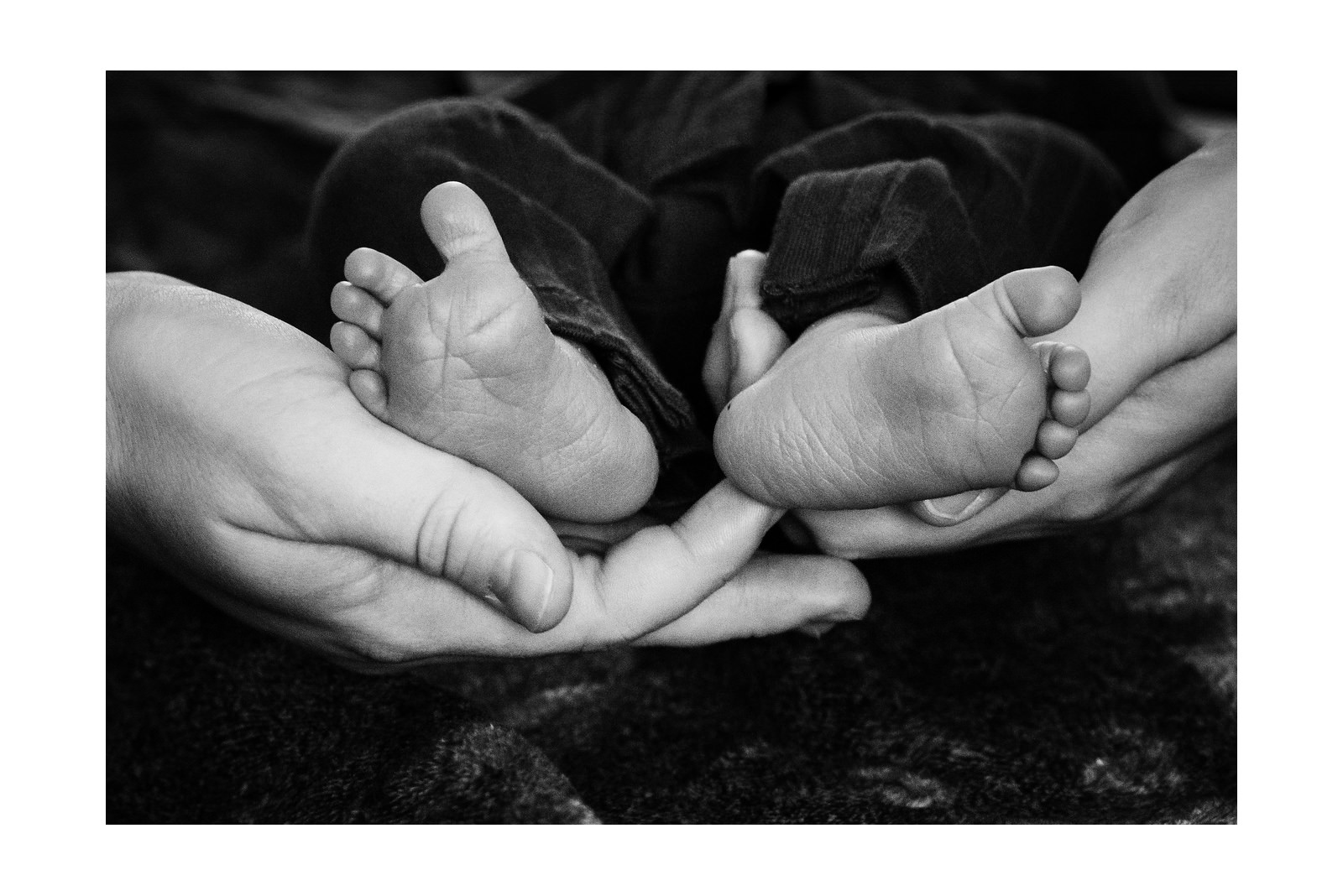 Newborn baby details that show mom's hands and the newborn's feet in Victoria BC