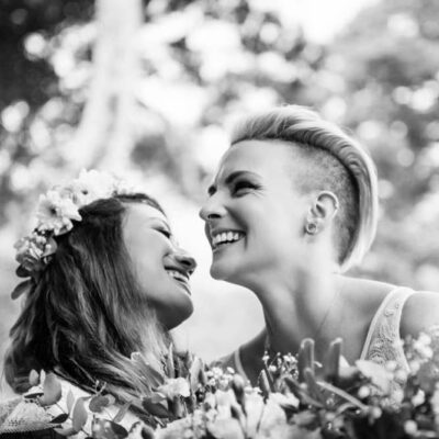 A lgbtq couple in black and white smiling and laughing as they see each other for the first time on their wedding date in Victoria BC